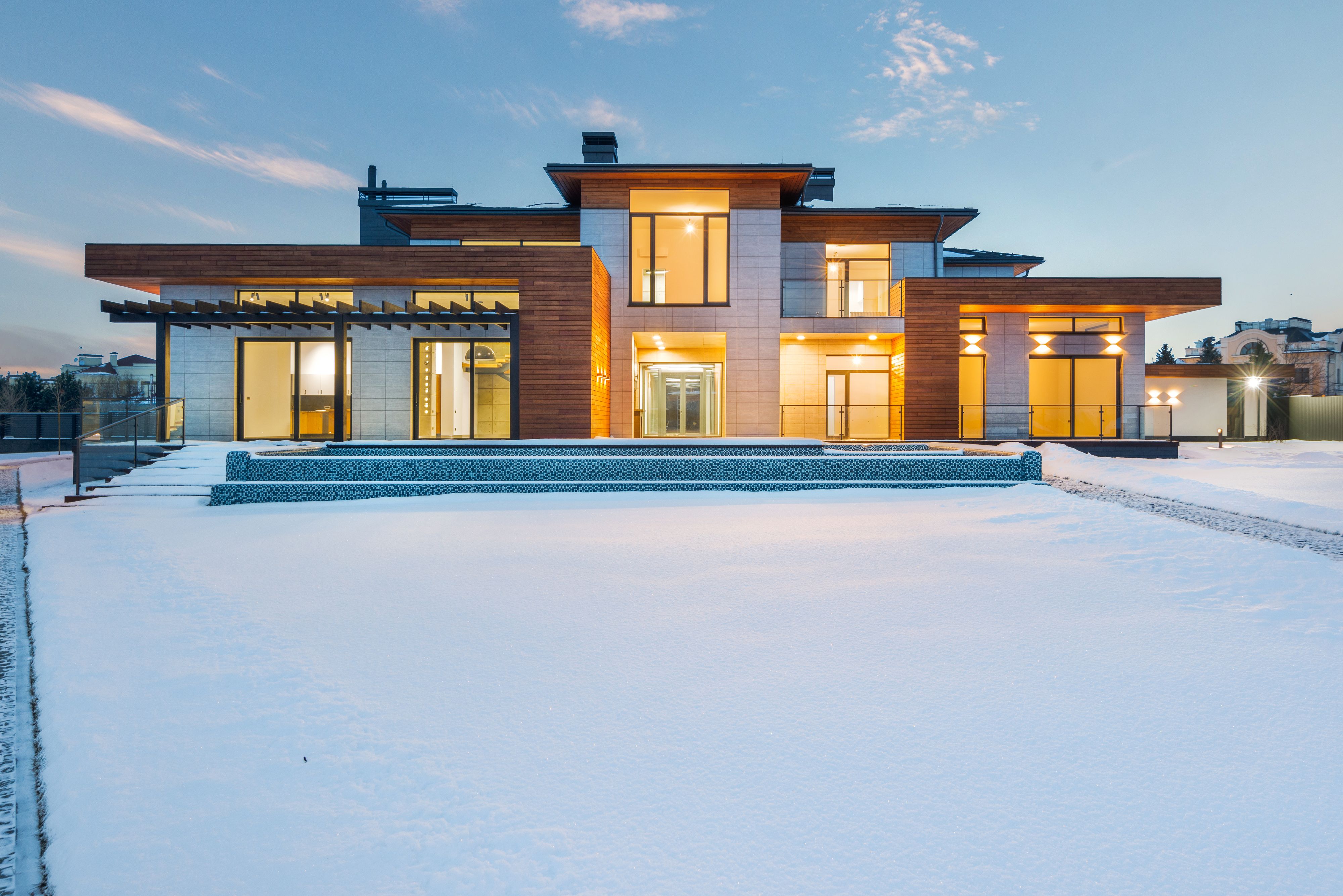 A modern Calgary home lit from within on a winter evening